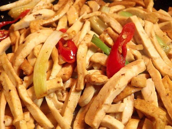 接著下豆干拌炒，炒至稍微焦香後加入醬油拌勻，再加入水跟所有調味料