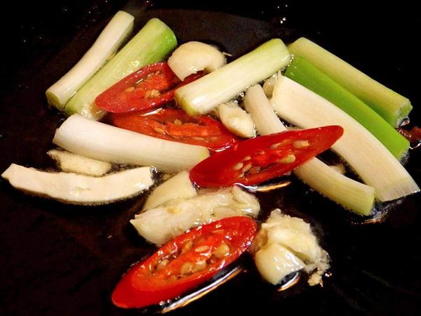 鍋裡留下一大匙的油，先爆香蔥白，蒜末及辣椒