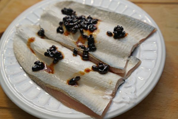 將豆豉淋在魚片上，再加入米酒。