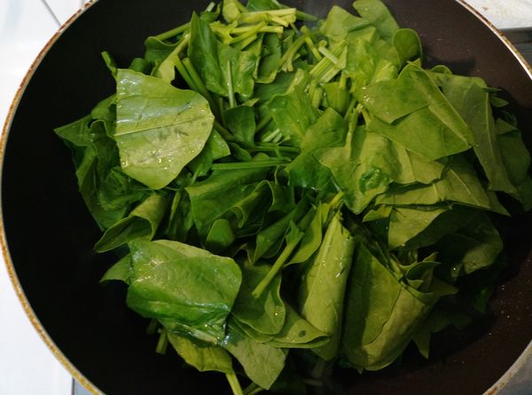 加入菠菜炒至八九分熟。