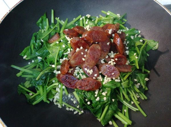 倒入剛煎過的臘腸，並撒點杏仁粒炒拌勻即可盛起。