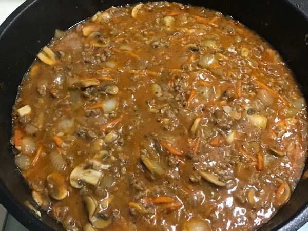 把蒜末倒入鍋中炒至金黃，丟入牛絞肉。等絞肉半熟，將洋蔥、義大利肉醬、番茄醬、義大利香料倒入鍋中拌炒。
等滾了之後，加入起司跟起司粉，攪拌均勻該上鍋蓋，悶五分鐘