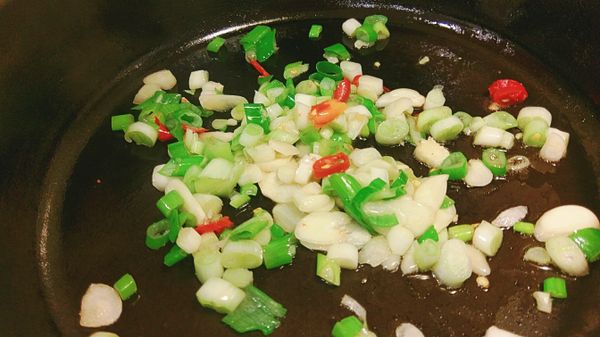 另取炒鍋加入少許的香油放入青蔥蒜片辣椒炒出香氣