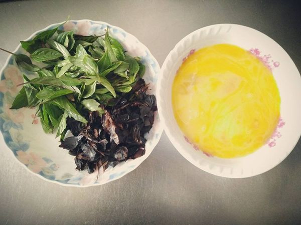 洗淨九層塔、剝黑蒜頭、剝黑蒜皮、切薑片、打蛋攪拌，備用 ;