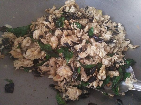 倒入黑麻油熱鍋，再把黑蒜頭和黑蒜皮爆香，等待香氣出來時再依序放入攪拌的蛋，看蛋液快成蛋形，以最小火烘至呈金黃色，再快炒成散蛋 ;