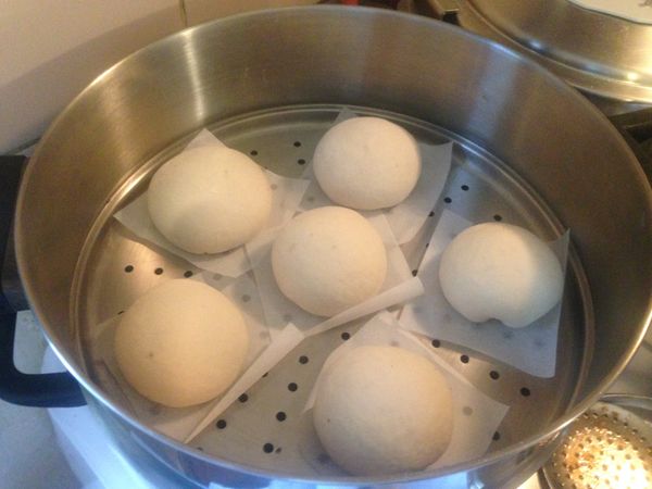 蒸籠的下層放上熱開水，再把放滿芝麻包的蒸盤放上去蓋上蓋子，進行二次發酵。如圖。