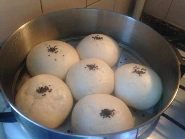 超值巨大的芝麻包就可以出爐了。記得時間到了以後，馬上關火，可是不要馬上揭蓋子，等一會兒再打開，這樣子可以讓包子保持形狀飽滿，不容易凹陷。好久沒吃芝麻包了，老媽很高興，我也重新回味了這個懷念的滋味。有興趣的朋友不妨試試看喔，清爽好吃不油膩。這個芝麻包太大了有點兒土氣，還是做八個或是更小一點更精緻😅