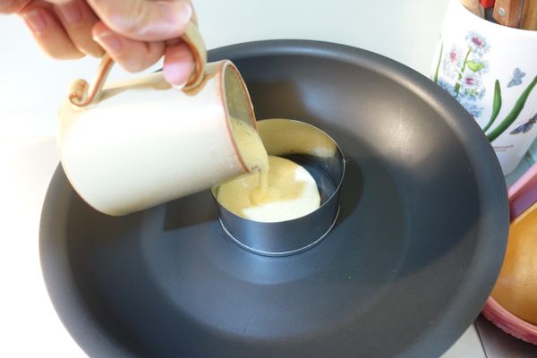 直徑十公分的圓形模放置在不沾鍋上並倒入八分滿的麵糊到模型中