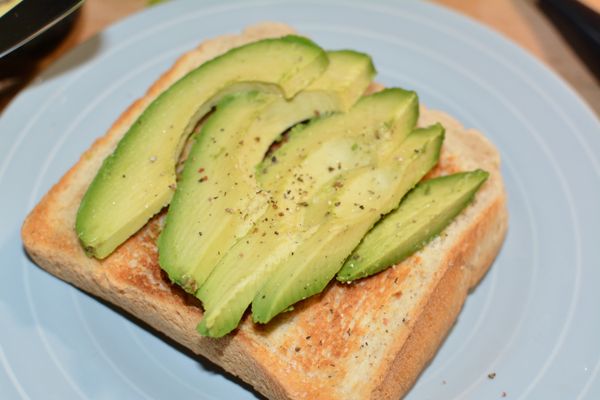將酪梨片排列在吐司上，撒上鹽、胡椒，再放上幾片香菜，最後將水煮蛋取出放在紙巾上吸乾水份，再放在酪梨片上，灑上少許胡椒即完成。