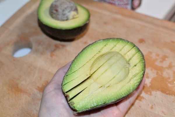 在等待蛋煮熟的過程中來切酪梨，把酪梨切半後切成片狀。