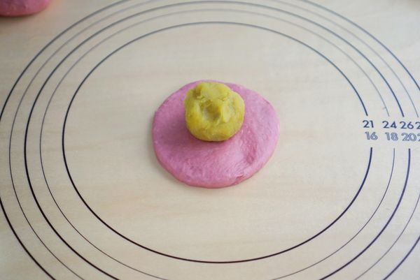 用手壓成邊緣薄中間厚的麵糰，再放置地瓜泥。