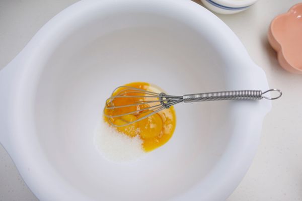 把蛋黃均勻打散後加入細砂糖攪拌至溶化後加入植物油和水麵粉過篩兩次後加入並攪拌均勻