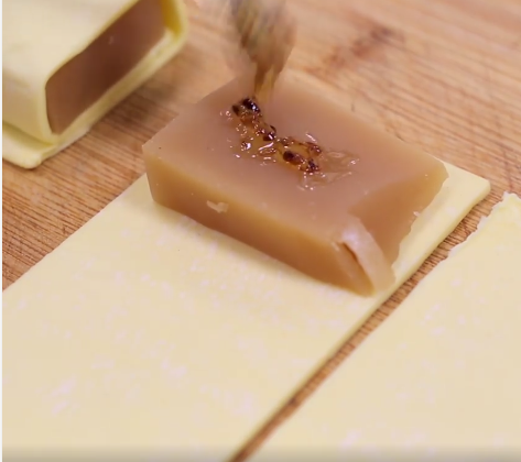 將酥皮裁成可以包裹著年糕的大小後放上年糕並塗上適量桂花醬後包裹起來，記得派皮接口朝下會比較美