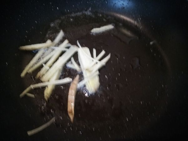 平底鍋加入橄欖油，薑洗淨先切片再切成絲，放入鍋中爆香。