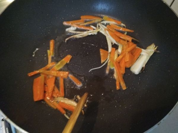 紅蘿蔔刨去外皮，先切成片再切成細絲，放入鍋中炒出香氣和甜度。