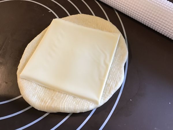 將小麵團四周擀開，放上一片起司片