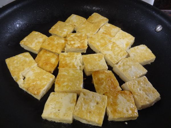 起鍋熱油兩匙，放入平底鍋將豆腐煎成兩面金黃色後盛起。