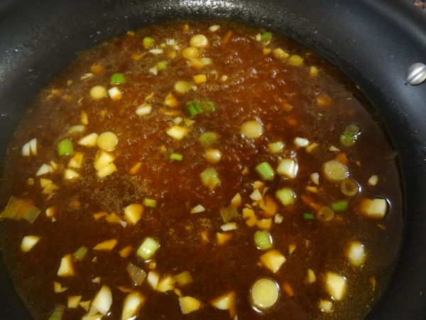 就鍋內剩餘的油，將蔥白及蒜粒先放入爆香，隨後陸續放入醬油、糖、番茄醬、及一碗水煮開。