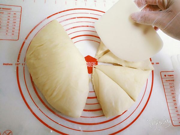 (取出完成初次發酵後的麵糰)，先從上壓下去擠出麵糰空氣，再用刮板先切8等份、每等份再平均分成2份，總共16份。