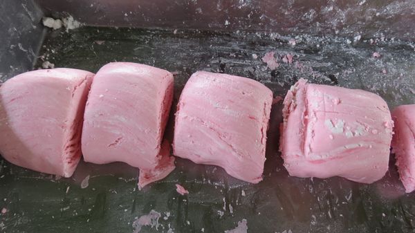 將糯米糰揉光滑後，將紅色、白色糯米糰各分成等重量小圓糰，放在手心搓圓之後壓扁，用大拇指、食指輕輕按壓成一個碗狀，之後放入花生餡再包起來。