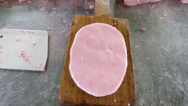 在龜模上刷上油防沾黏後將已包花生餡的糯米糰放到龜模上，輕輕的壓扁成一個烏龜狀，在表面上再刷上一層油