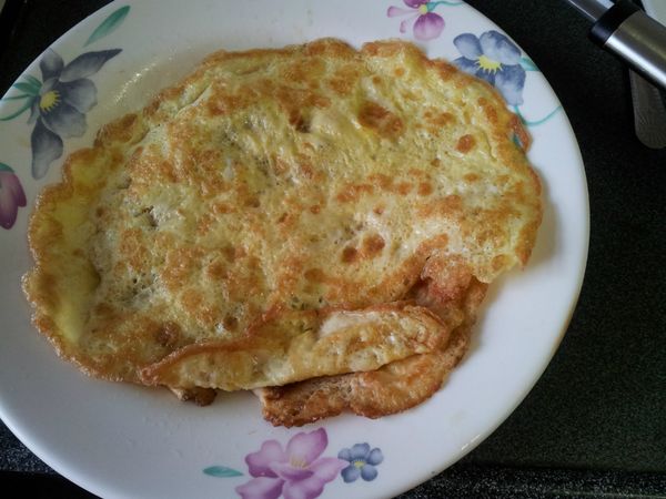 將蛋皮攤開，中間放飯再對折