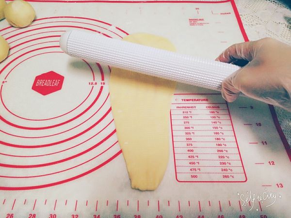 (20分鐘過後)將小麵糰搓揉成水滴形，一手拉著尖端處，擀成長條狀