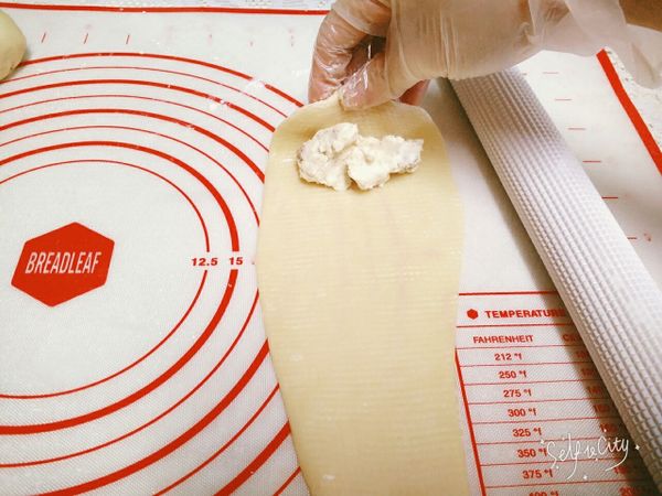 在較寬的地方，放入適量的內餡料(前面做的焦糖乳酪核桃)，由寬的地方順著往下捲，不用捲過緊