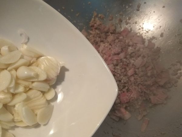 蒜頭剝去外膜切成片，放入鍋中爆香。