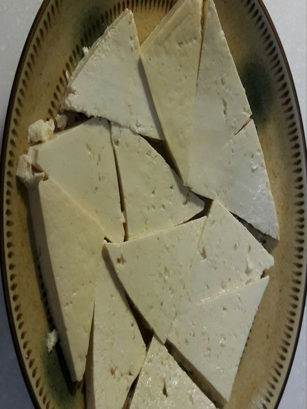 將豆腐切片，平鋪在盤子裡。