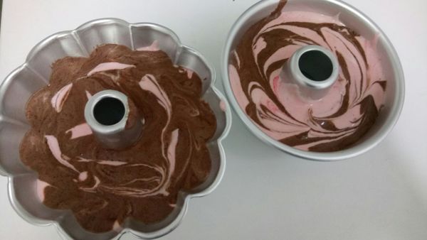 先倒入可可麵糊再倒入草莓麵糊，輕輕攪拌兩下就好(攪拌太多花紋會不好看)，之後用力的摔兩下模具讓空氣摔出來