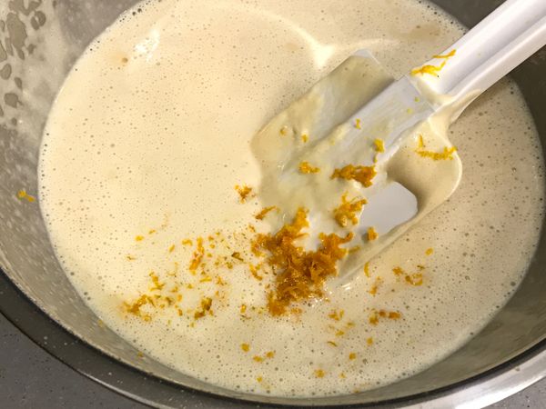 依序加入麵粉、牛奶、奶油及橙皮，用刮刀輕輕拌勻。