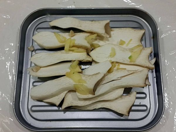 將杏鮑菇放置烤盤，杏鮑菇上撒蒜頭
放入烤箱大火約3分鐘