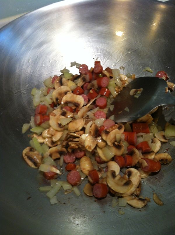 再將熱狗及洋菇一起放入拌炒