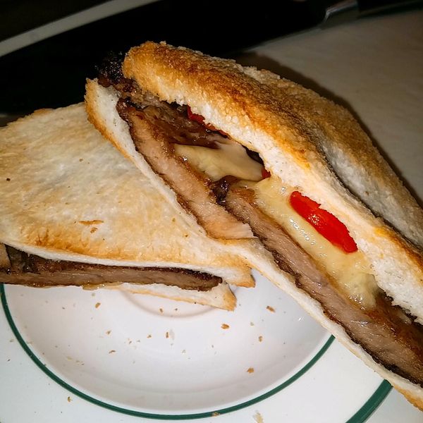 切掉吐司的邊緣，把肉排舖上去，把乳酪絲舖上，再放上蕃茄片，對切後放入烤箱，調好時間，就可以享用豬排三明治了