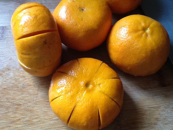 3.以刀具將每一顆茂谷柑周邊均等的切8刀，不切斷(上下不切)。