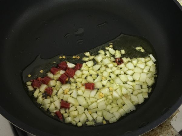 放入蒜頭、辣椒，小火慢炸