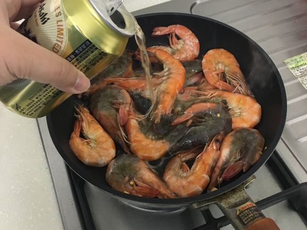 蝦子外殼稍微紅後，倒入啤酒並蓋鍋悶煮