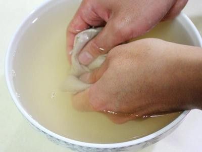 取2400c.c冷開水倒入大碗中，將已裝袋的愛玉子放在水面下，溫柔搓洗約5分鐘。