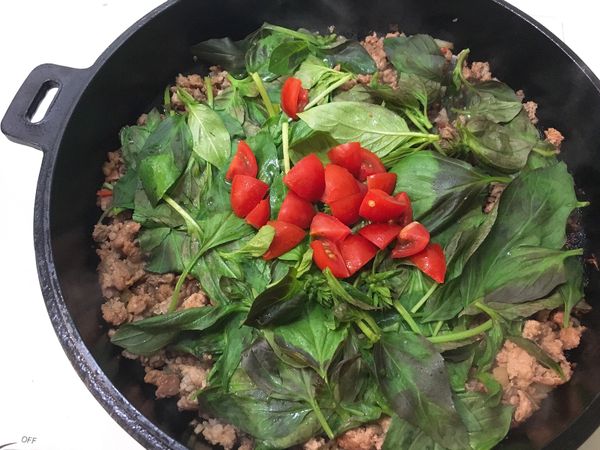 辛香料推到邊邊後轉中火，
下豬絞肉，單面煎香後拌炒開，
放入九層塔與蕃茄與調味料後拌勻。