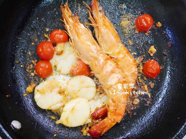 平底鍋先以小火炒香洋蔥及蒜頭碎後再加入小蕃茄及、干貝與大草蝦並炒到熟後加入些許的白葡萄酒然後先將海鮮的部份取出