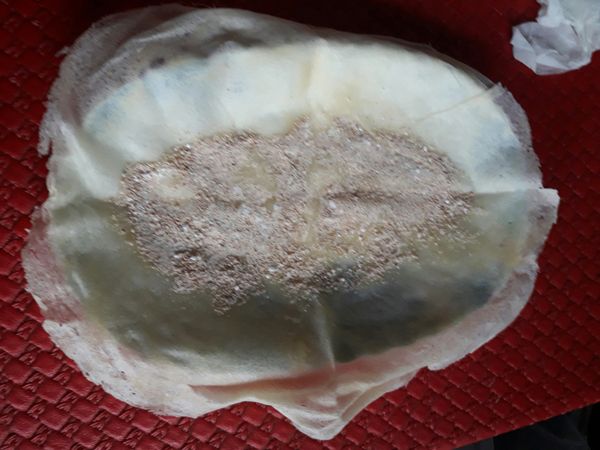 找個長盤 將潤餅皮攤開 均勻灑上拌好的花生糖粉  把長邊的其中一邊往中間折 短邊兩邊往中間折一公分再將長邊的另一邊內折