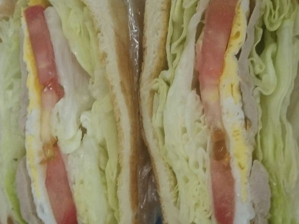 用手把包裹的食材,壓密緊實,使用刀具將三明治對半切開即可以食用。