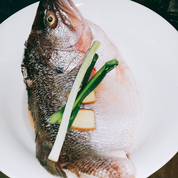 魚片清洗後放上半根青蔥，將薑片放置魚肉的底部，加入少許的米酒，放入電鍋內蒸熟