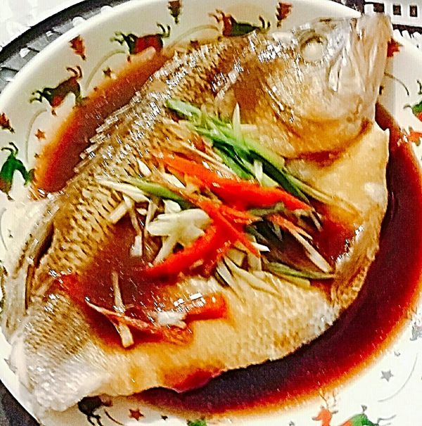 青蔥，紅辣椒，老薑全部切成絲，舖設在蒸熟的魚肉上，調味醬汁再滾一遍，趁滾燙時淋在魚肉上面就完成了