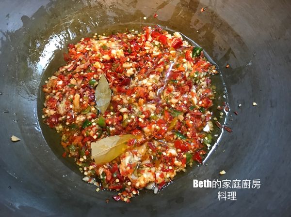 放入辣椒碎、蒜蓉、月桂葉，蓋過食材的沙拉油，小火炒至沙拉油變紅