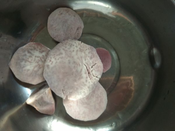 將芋頭削去外皮，放進傳統電鍋裡蒸煮到熟，放到料理碗內。（芋頭可以一次蒸煮整顆，取適量的芋頭片來做這道菜即可。