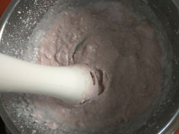 使用小型食物料理機將芋頭和牛奶攪打成泥，在攪打過程中會一併將砂糖打化。