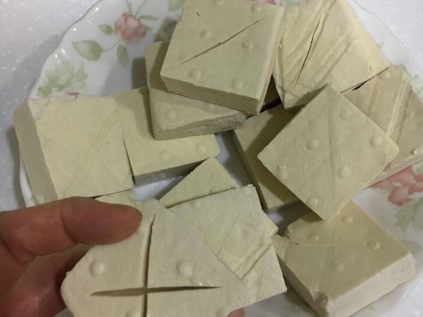 臭豆腐沖淨，可在表面劃X，使之更容易入味。
我的臭豆腐一包有15片，大小約4.5x4.5公分。

         蒜切末備用