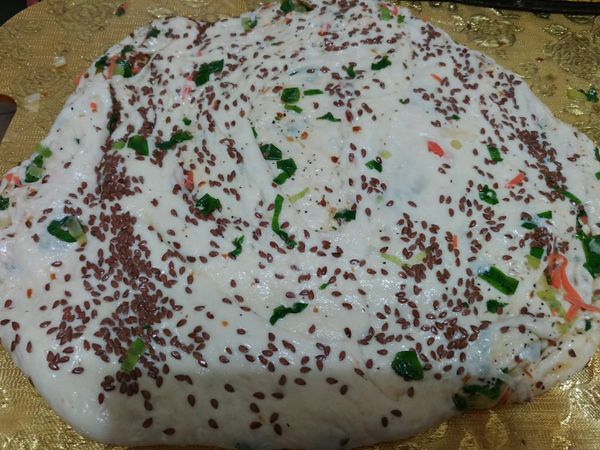 噴些水，灑上亞麻仁籽，用桿麵棍桿成圓薄形狀。(2~3公分厚)